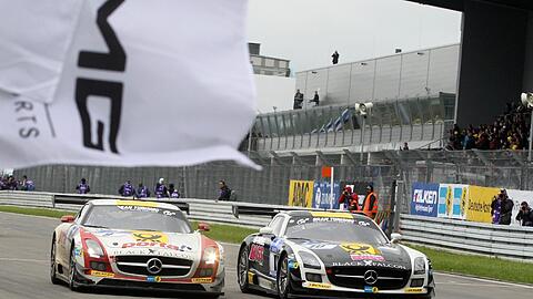Der Mercedes SLS des Teams Black Falcon (l) fährt am 20.05.2013 mit Bernd Schneider, Jeroen Bleekemolen Sean Edwards und Nicky Thiim auf dem Nürburgring bei Nürburg (Rheinland-Pfalz) als Sieger über die Ziellinie.