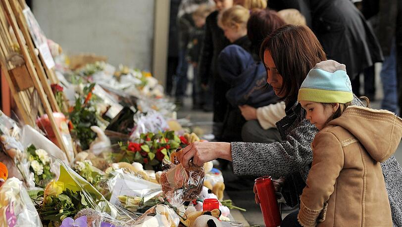 Eine Familie legt Blumen vor der Kinderkrippe "Fabeltjesland" ab. Eine Familie legt Blumen vor der Kinderkrippe "Fabeltjesland" ab.