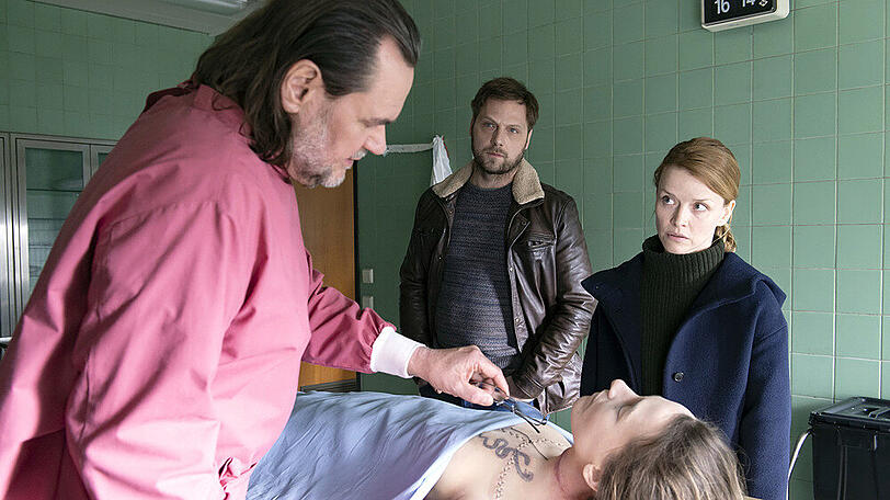 "Die Toten am Meer": Ria Larsen (Karoline Schuch) und Mattern (Ronald Kukulies) sind gespannt auf die Obduktionsergebnisse von Bernhard Metzger (Markus John)