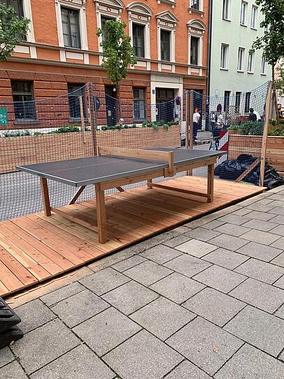 Auch eine selbstgebaute Tischtennisplatte steht jetzt auf einem der früheren Parkplätze, mit Netz, dass der Ball nicht auf die Straße rollt.