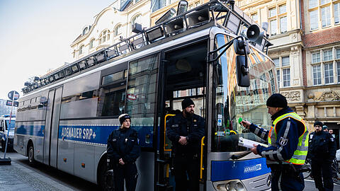Polizisten stehen um den umgebauten Gefängnisbus "Adenauer SRP+".