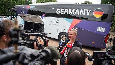 Alexandra Popp gibt bei der Abreise der DFB-Frauen vor dem Teambus Interviews.