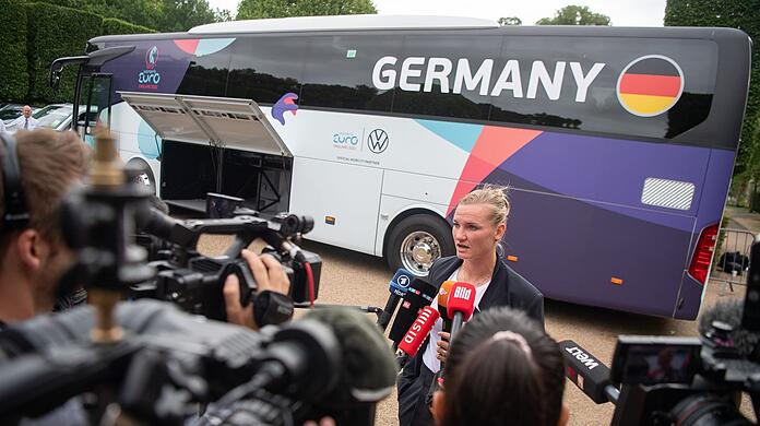 Alexandra Popp gibt bei der Abreise der DFB-Frauen vor dem Teambus Interviews.