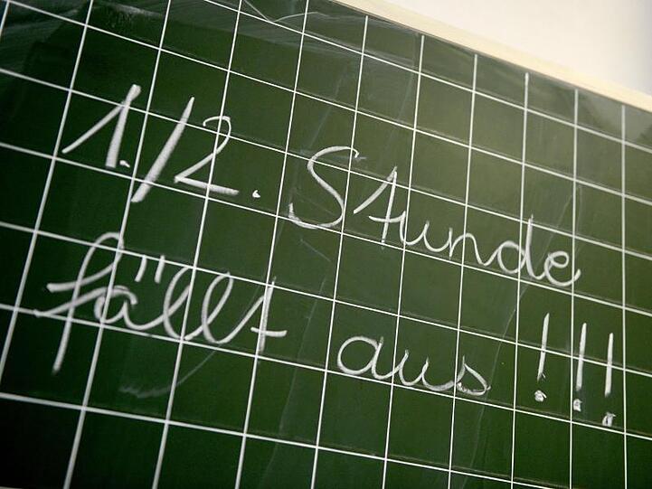 Auf einer Tafel steht der Schriftzug "1./2. Stunde fällt aus!!!". Foto: Caroline Seidel/Archivbild