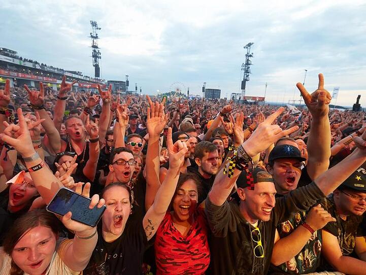 Musikfans jubeln auf dem Gelände des Festivals &bdquo;Rock am Ring&ldquo; 2019. Foto: Thomas Frey/dpa/Archivbild