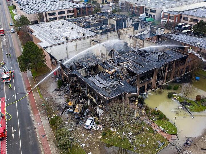 Die Feuerwehr löscht eine ausgebrannte Lagerhalle nach einem Großbrand in der Nacht.