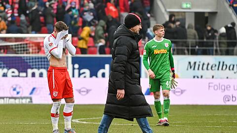 Die Mannschaft von Regensburg steht nach dem verlorenen Spiel gegen Düsseldorf enttäuscht auf dem Rasen.