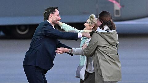 Olivier Vandecasteele (l) trifft seine Familie bei der Ankunft auf dem Militärflughafen Melsbroek.