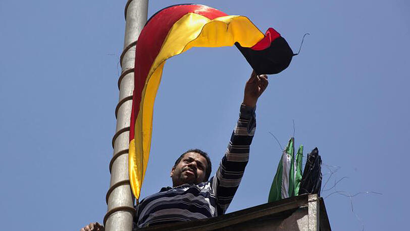 Vor dem Besuch von Kanzlerin Merkel in Ägypten bringt ein Arbeiter in Kairo die deutsche Flagge an einer Straßenlaterne an. Vor dem Besuch von Kanzlerin Merkel in Ägypten bringt ein Arbeiter in Kairo die deutsche Flagge an einer Straßenlaterne an.