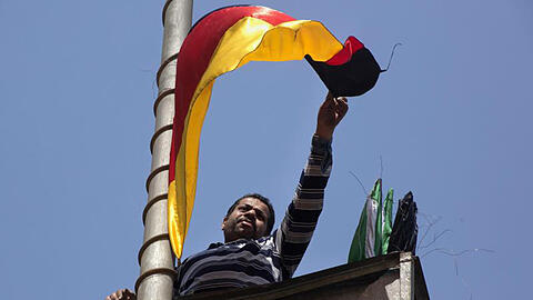 Vor dem Besuch von Kanzlerin Merkel in Ägypten bringt ein Arbeiter in Kairo die deutsche Flagge an einer Straßenlaterne an.