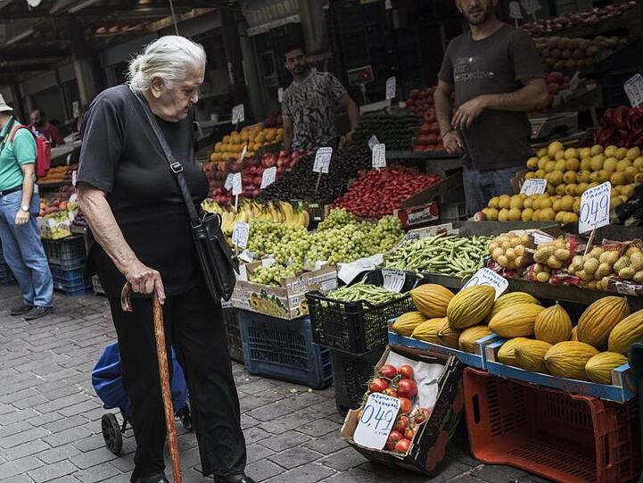 Eine ältere Frau geht in Athen an Marktständen vorbei. Viele Griechen sind von Armut bedroht.