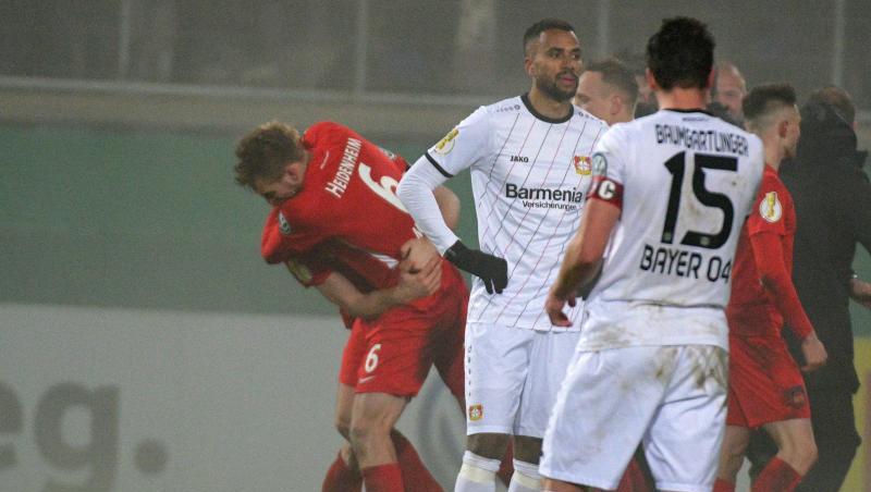 Während die Heidenheimer im Hintergrund ihren Sieg feiern, lassen die Spieler von Bayer Leverkusen nach dem Aus im Pokal-Achtelfinale die Köpfe hängen. Während die Heidenheimer im Hintergrund ihren Sieg feiern, lassen die Spieler von Bayer Leverkusen nach dem Aus im Pokal-Achtelfinale die Köpfe hängen.