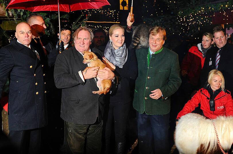 Gerard Depardieu, Kathrin Glock, Michael Aufhauser und ein kleiner Vierbeiner bei der Eröffnung des Weihnachtsmarktes auf Gut Aiderbichl