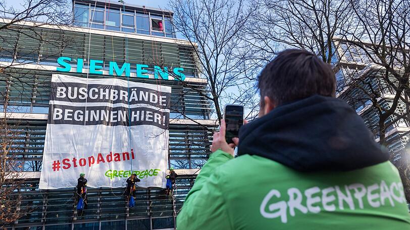 Einen Tag vor der Siemens-Hauptversammlung protestiert die Umweltorganisation Greenpeace gegen den Beitrag des Industriekonzerns für ein riesiges Kohlebergwerksprojekt des Adani-Konzerns in Australien.
