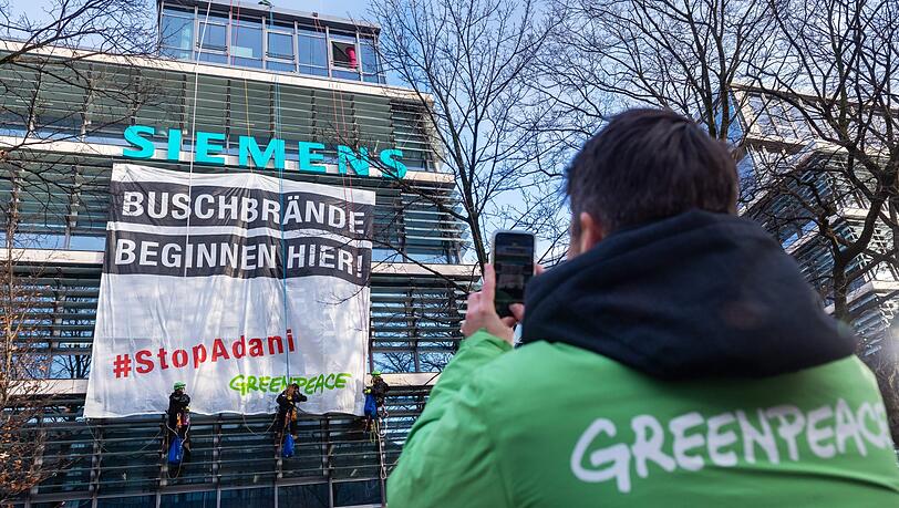 Einen Tag vor der Siemens-Hauptversammlung protestiert die Umweltorganisation Greenpeace gegen den Beitrag des Industriekonzerns für ein riesiges Kohlebergwerksprojekt des Adani-Konzerns in Australien.