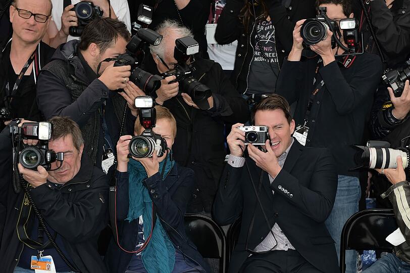 Erkennen Sie den VIP? Der Schauspieler Channing Tatum sitzt bei den Filmfestspielen in Cannes inmitten der Pressefotografen zum Fototermin zu seinem neuen Film "Foxcatcher". Er will ein Bild von seinen Schauspielkollegen knipsen und wird dabei selbst zum Fotomotiv.