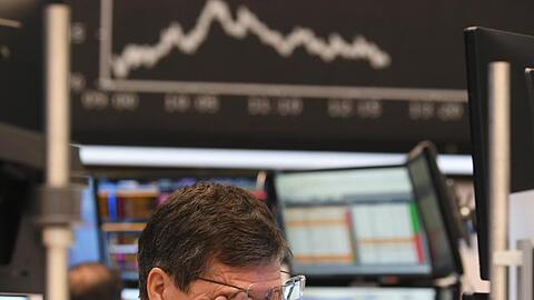 Ein Aktienhändler reibt sich auf dem Parkett der Frankfurter Börse die Augen.