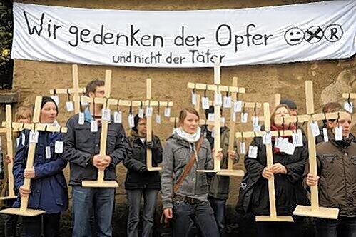 Mit Holzkreuzen erinnern Teilnehmer der Protest-Kundgebung vor dem Friedhof von Wunsiedel an die Opfer rechter Gewalt.