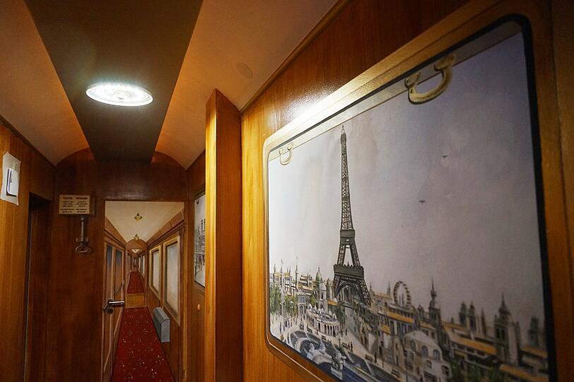 Ein Kirchenmaler gestaltet die Hotelflure so, dass man sich an die Haltestellen des Zugs versetzt fühlt. Hier: Paris.