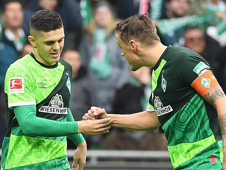 Werder Bremens Max Kruse (r) gratuliert Milot Rashica zu seinem Tor zum 3:0.