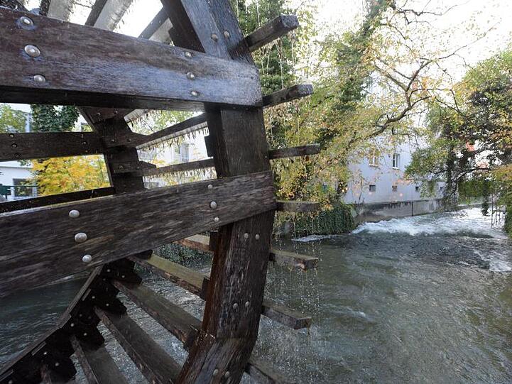 Ein Wasserrad dreht sich in Augsburg an einem Stadtkanal. Foto: Stefan Puchner/dpa/Archivbild