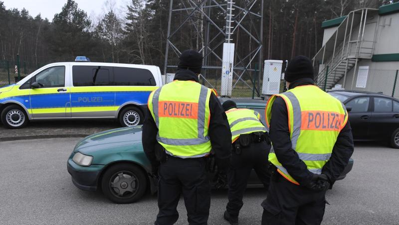 Polizisten kontrollieren ein Fahrzeug vor einem Grenzübergang nach Polen.