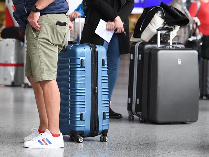 Flugreisende stehen in Terminal 1 des Frankfurter Flughafens am Check-in-Schalter an. Reiserückkehrer aus Risikogebieten sollen sich an Flughäfen verpflichtend auf das Coronavirus testen lassen.