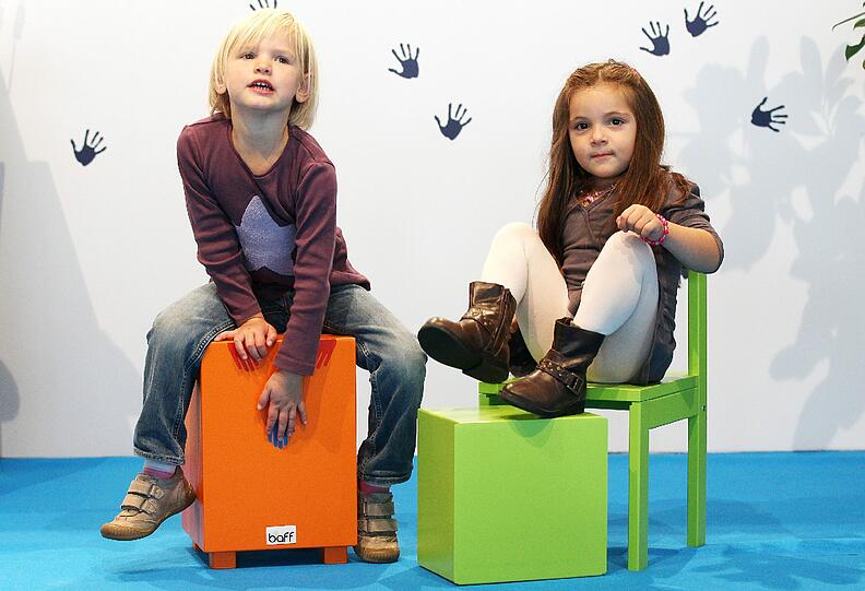 Auf Musikmöbeln trommeln in Köln auf der Messe Kind+Jugend zwei Kinder vor.