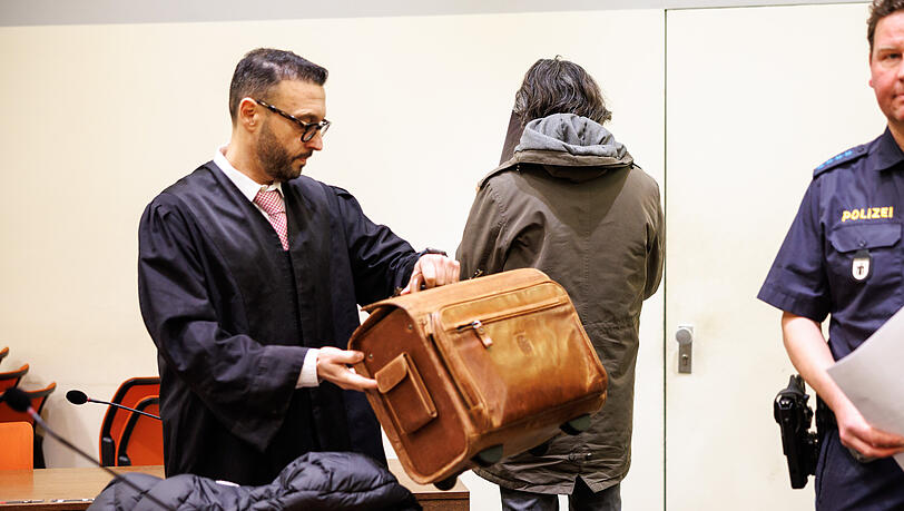 Ein angeklagter Mann, der seine Gönnerin aus Habgier getötet haben soll (M), steht vor Prozessbeginn in einem Gerichtssaal vom Landgericht neben seinem Rechtsanwalt Adam Ahmed.