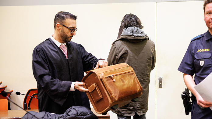 Ein angeklagter Mann, der seine Gönnerin aus Habgier getötet haben soll (M), steht vor Prozessbeginn in einem Gerichtssaal vom Landgericht neben seinem Rechtsanwalt Adam Ahmed.