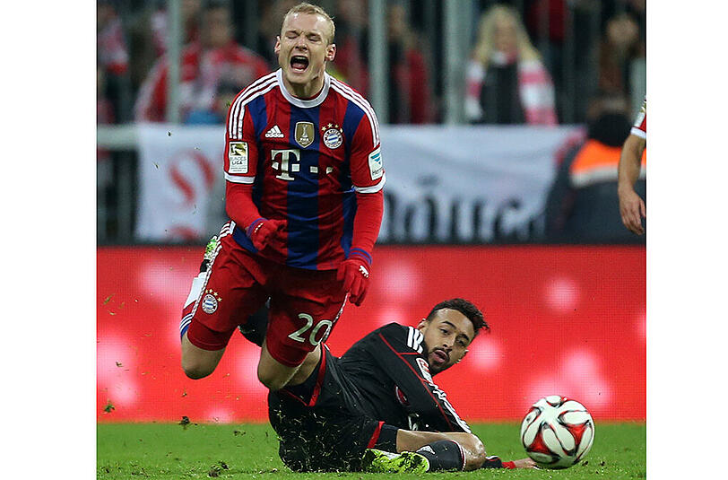 Karim Bellarabi kommt von seitlich hinten angeflogen und senst Sebastian Rode um.