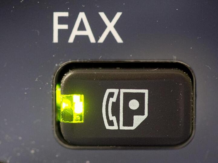 Das Licht an dem Knopf eines Fax-Gerätes leuchtet. Foto: Kay Nietfeld/Archivbild