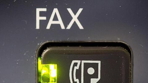 Das Licht an dem Knopf eines Fax-Gerätes leuchtet. Foto: Kay Nietfeld/Archivbild