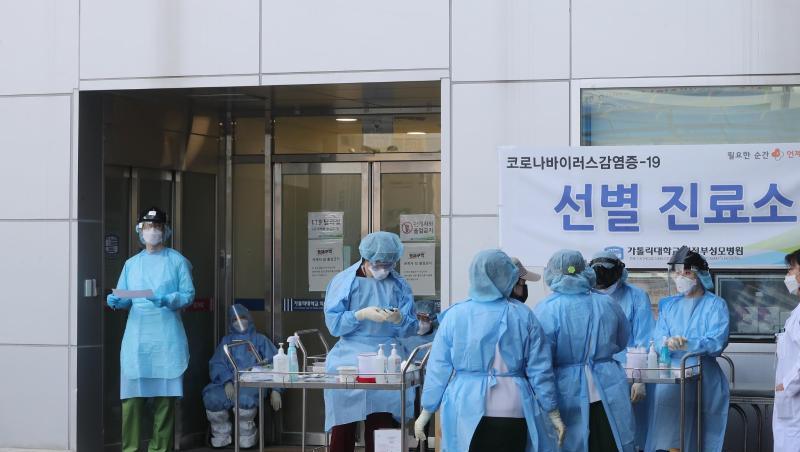Medizinisches Personal in Schutzausrüstung steht vor einem Krankenhaus in Südkorea. Medizinisches Personal in Schutzausrüstung steht vor einem Krankenhaus in Südkorea.