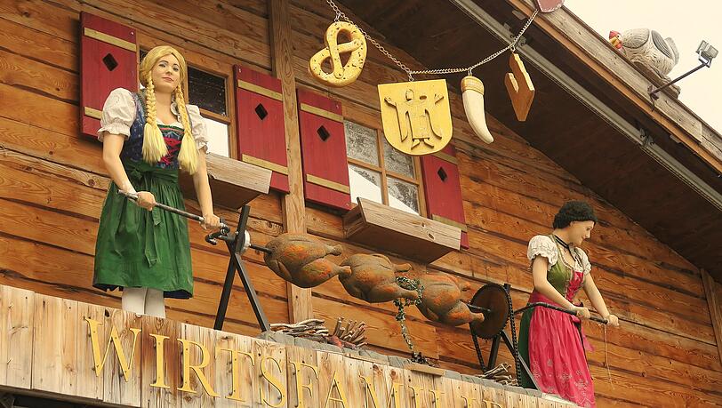Die ersten Hendl drehen sich bereits am Spie&szlig;: Hoch droben beim Wiesnzelt Goldener Hahn ist die Au&szlig;endeko mit Puppen, Papphendln und Co. schon so gut wie einsatzbereit.