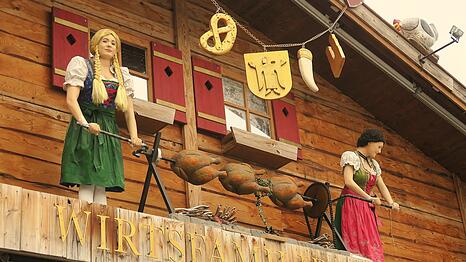 Die ersten Hendl drehen sich bereits am Spie&szlig;: Hoch droben beim Wiesnzelt Goldener Hahn ist die Au&szlig;endeko mit Puppen, Papphendln und Co. schon so gut wie einsatzbereit.