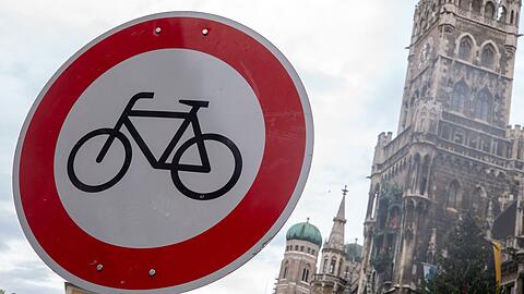Ein "Radfahren verboten"-Verkehrsschild ist in der Innenstadt vor der Kulisse der Frauenkirche und des Rathauses zu sehen.