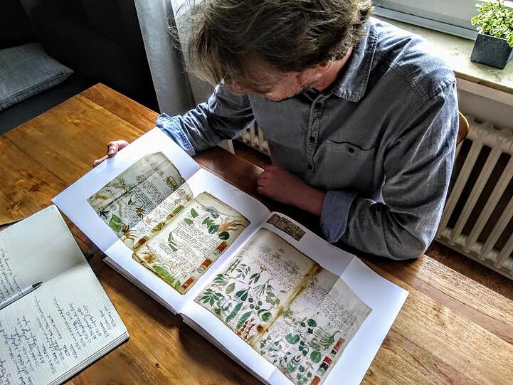 Der Computerlinguistiker Jürgen Hermes mit einem Faksimile des berühmten Voynich-Manuskripts.