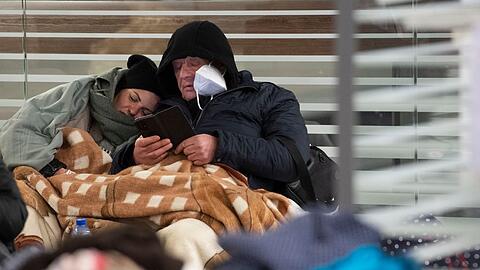 Zwischen Reisetaschen sitzend warten aus der Ukraine geflüchtete Menschen am Sonntagmorgen am Berliner Hauptbahnhof auf ihre Weiterreise.