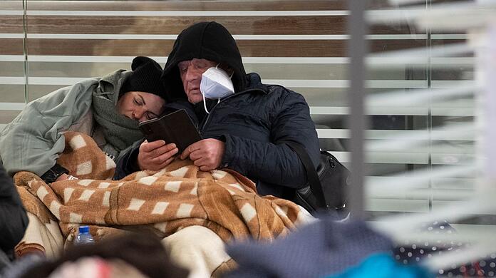 Zwischen Reisetaschen sitzend warten aus der Ukraine geflüchtete Menschen am Sonntagmorgen am Berliner Hauptbahnhof auf ihre Weiterreise.