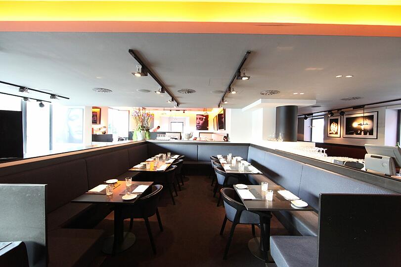 Puristisch und dunkel ist das Restaurant gehalten. Von der Dachterrasse aus blicken die Gäste über die Stadt, der Lärm von der Sonnenstraße scheint weit weg.