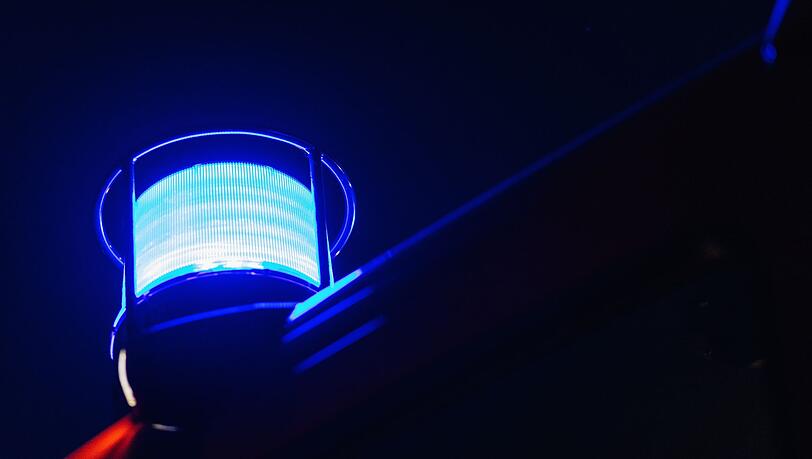 Ein Blaulicht leuchtet auf dem Dach eines Feuerwehrfahrzeugs.