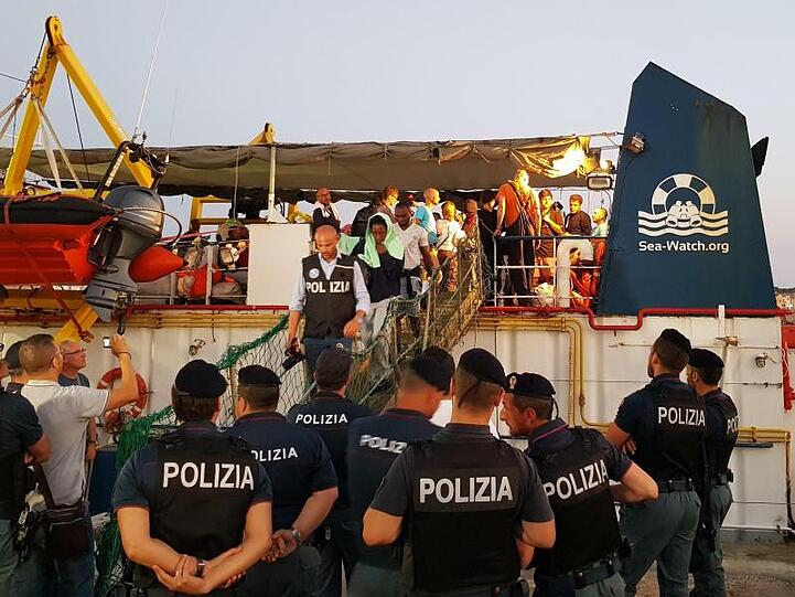 Migranten gehen im Hafen der Insel Lampedusa von Bord des Rettungsschiffs "Sea-Watch 3".