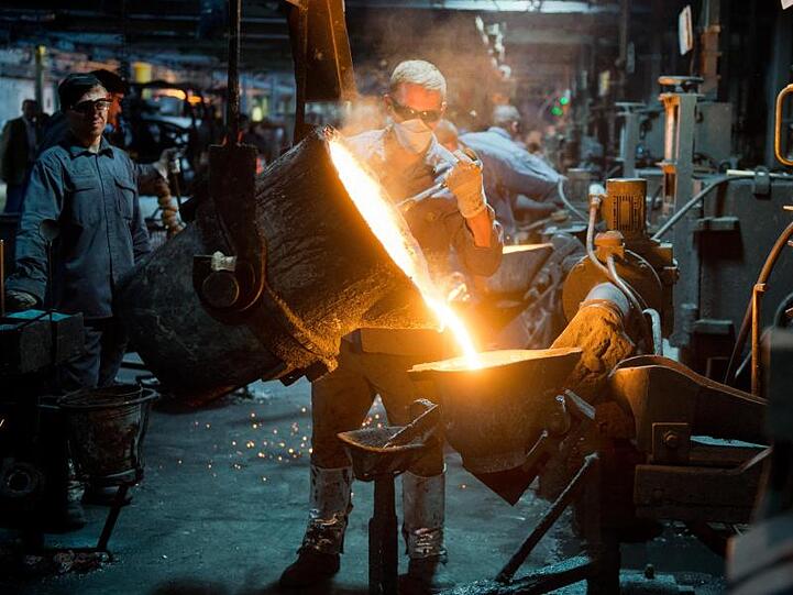 Ein Mitarbeiter gießt flüssiges Gusseisen im Werk eines Autozulieferers. Foto: Julian Stratenschulte/Archiv