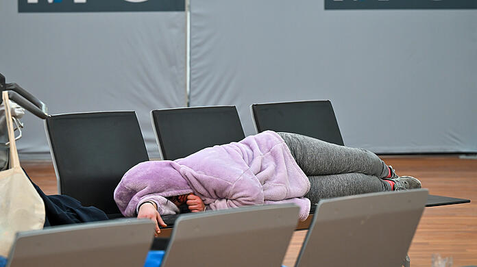 Verdi-Streik am Flughafen München: Eine Frau schläft in den Morgenstunden am Terminal 2 auf einer Bank im Abfertigungsbereich.