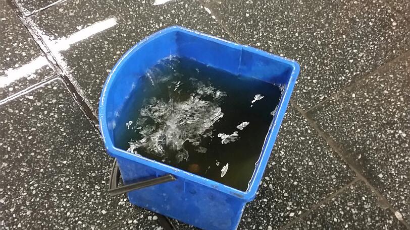 Eine schmutzige, schwarzbraune Brühe dümpelt im Eimer.