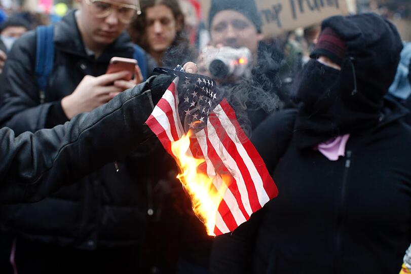Ein Demonstrant verbrennt eine US-Fahne in Portland.