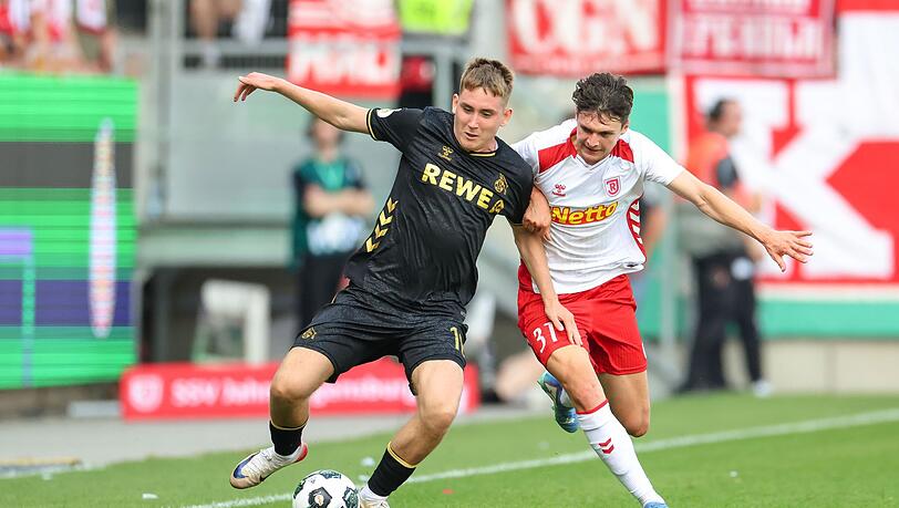 Köln-Neuzugang Isak Johannesson kämpft gegen Regensburg Leo Mätzler um den Ball.