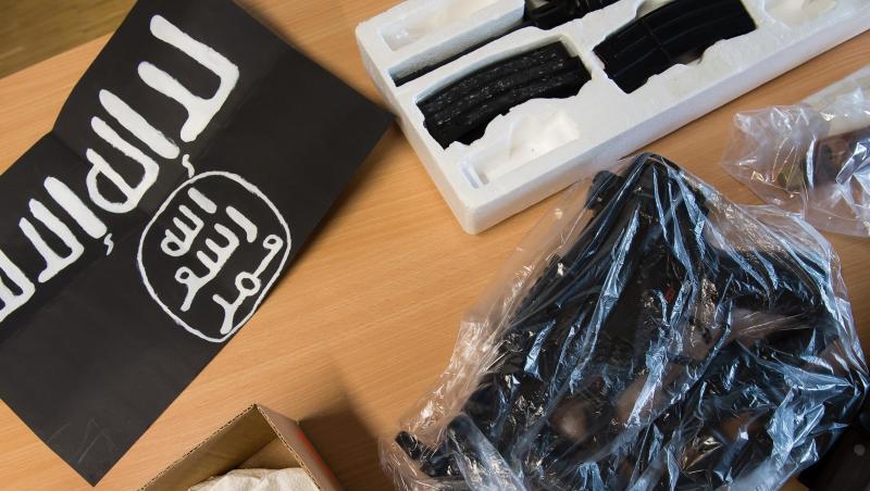 Beschlagnahmte Gegenstände liegen während einer Pressekonferenz der Polizei neben einer IS-Flagge. Beschlagnahmte Gegenstände liegen während einer Pressekonferenz der Polizei neben einer IS-Flagge.