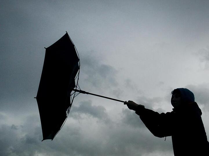 Ein Regenschirm eines Spaziergängers wird von einer Windböe erfasst. Foto: picture alliance / Karl-Josef Hildenbrand/dpa/Symbolbild